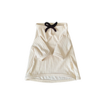 Beige baby outfit with black bow on a white background
