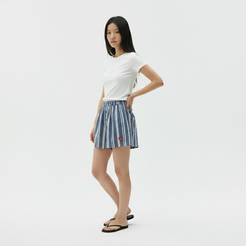 Woman wearing a white t-shirt and striped skirt on a plain background
