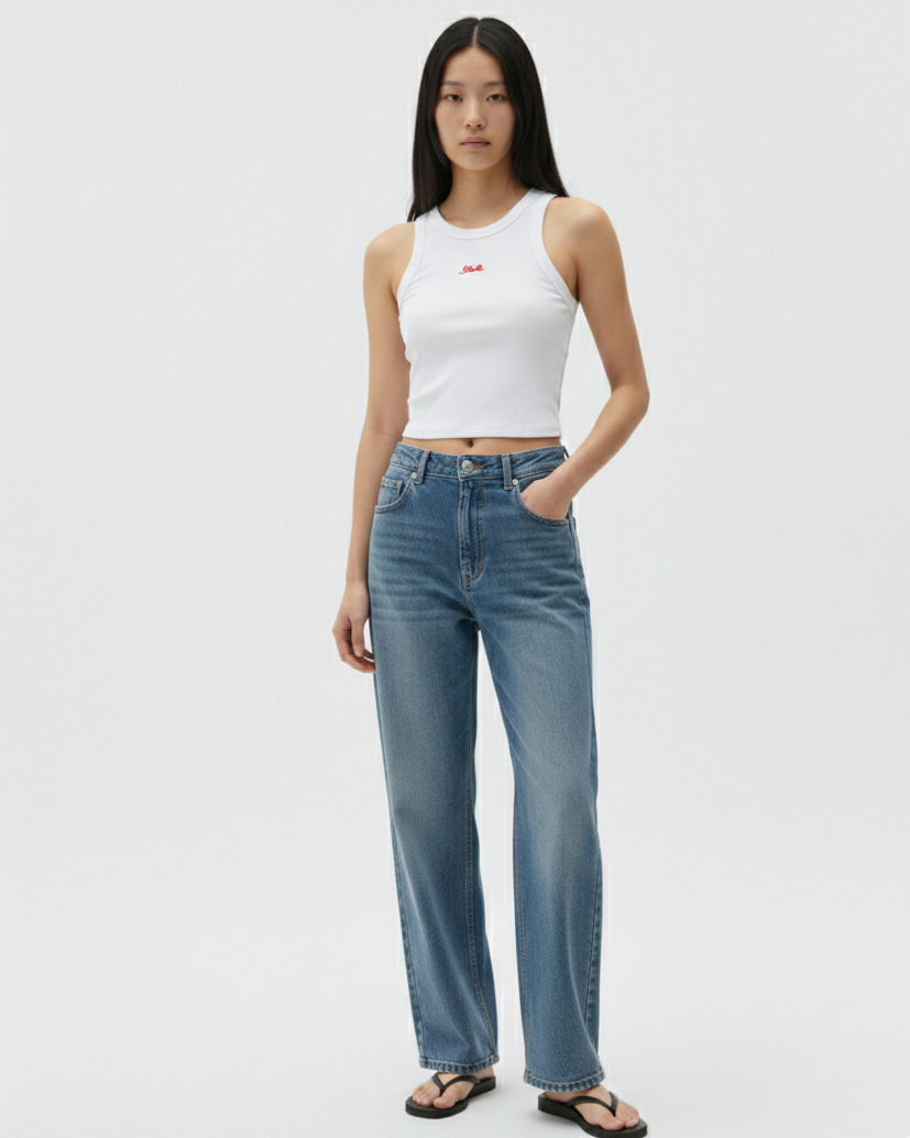 Woman wearing a white tank top and blue jeans on a white background