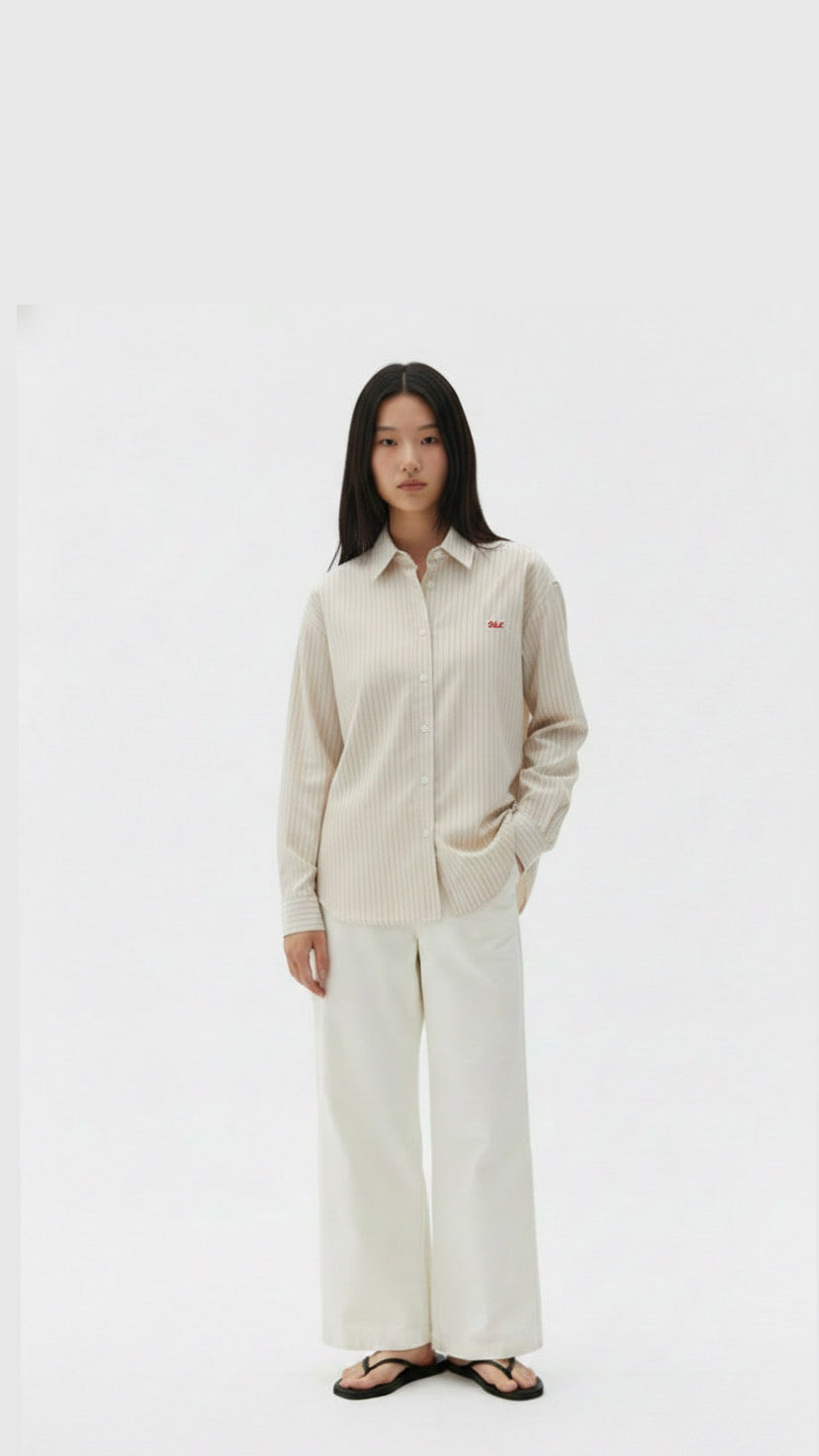 Woman wearing a beige shirt and white pants on a white background