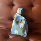 Knitted bag with cloud pattern on a brown leather couch