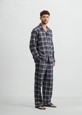 Man wearing a blue plaid pajama set on a white background