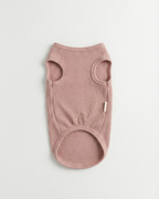 Pink ribbed dog sweater on a light gray background