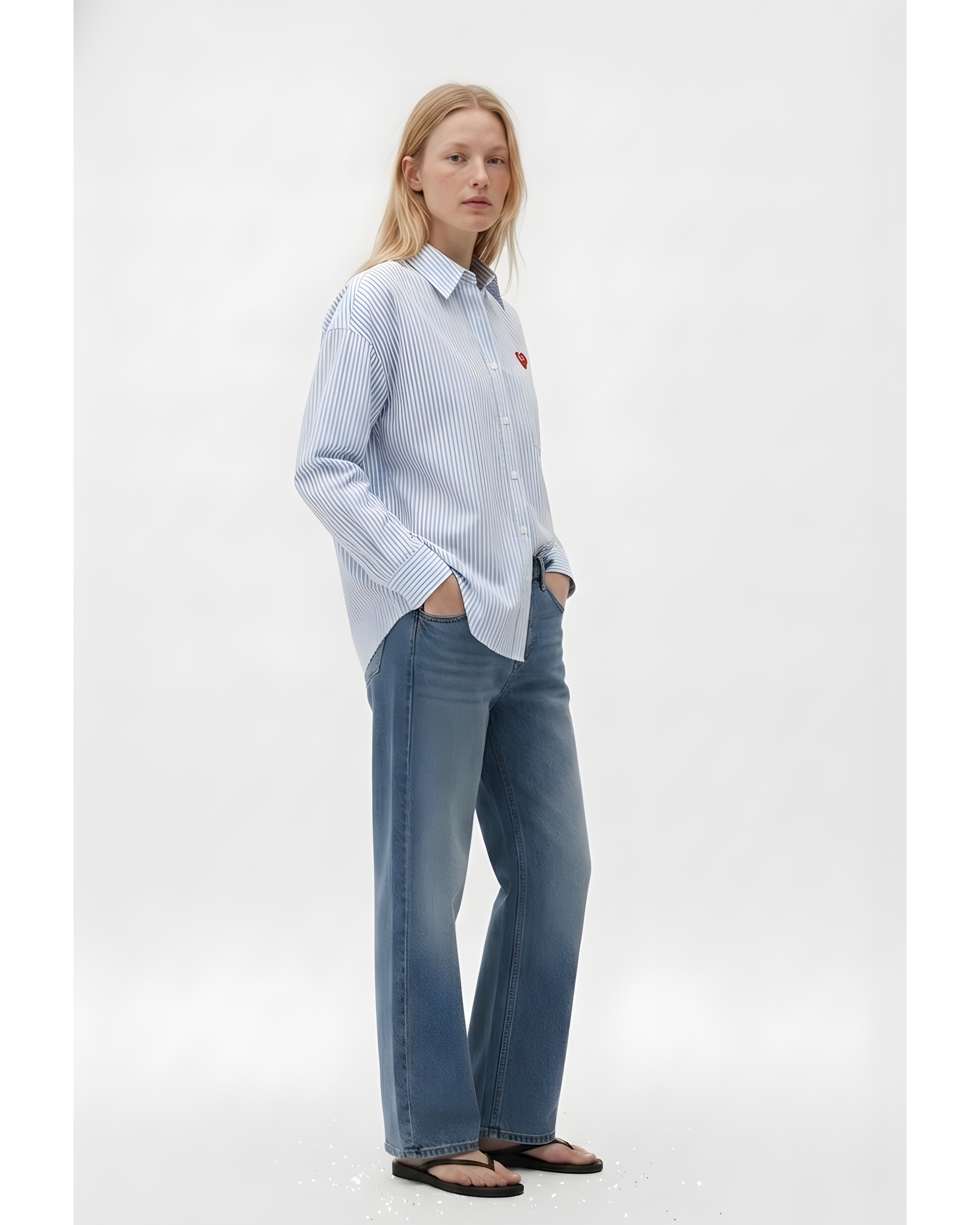 Woman wearing a light blue striped shirt and jeans on a white background