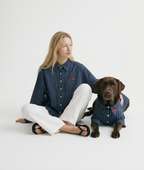Woman and dog wearing matching striped outfits on a white background
